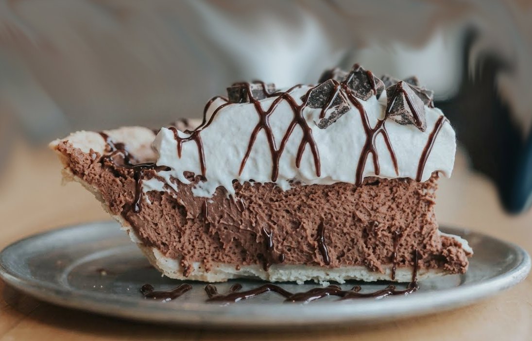 slice of chocolate pie with cream and chocolate syrup